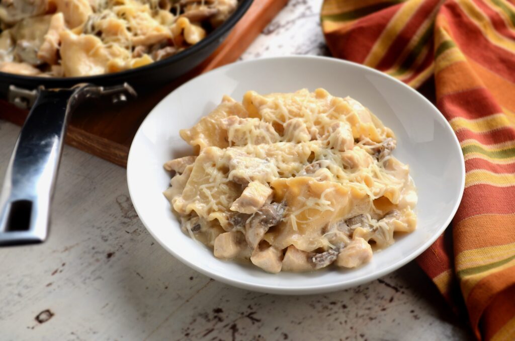 Lasagna strips, cubed chicken breast, and mushrooms in an Alfredo sauce, topped with shredded cheese